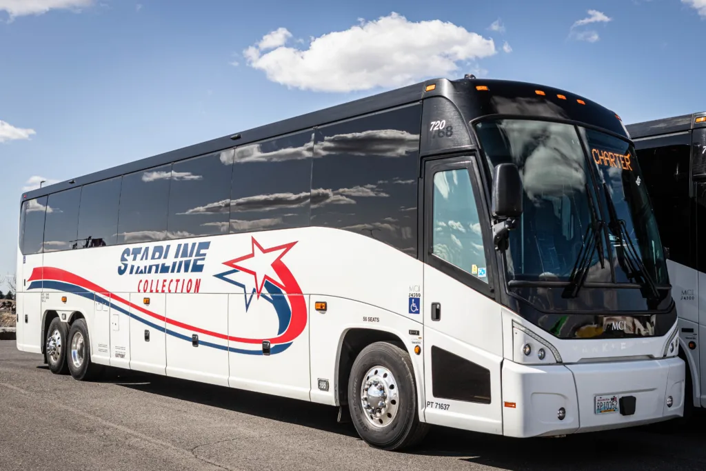 Starline Collection luxury MCI charter bus with bold red and blue branding under a clear blue sky