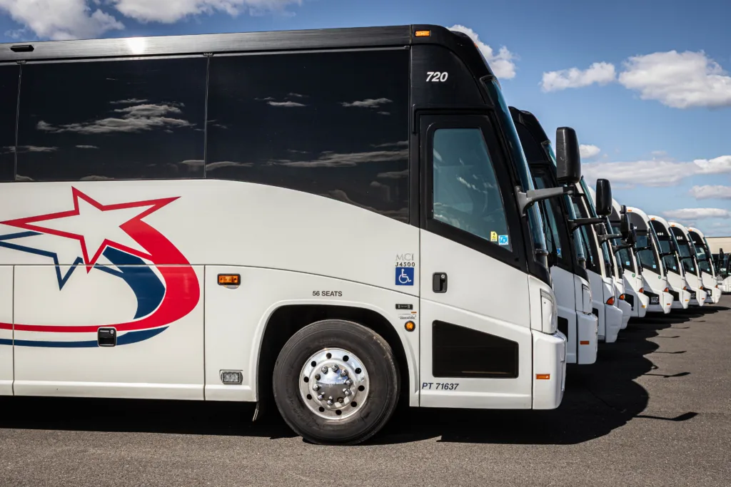 Row of Starline Collection luxury charter buses with bold star logo parked under a blue sky