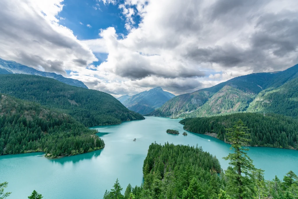 Aerial view of turquoise Diablo Lake surrounded by forested mountains in North Cascades National Park, Washington