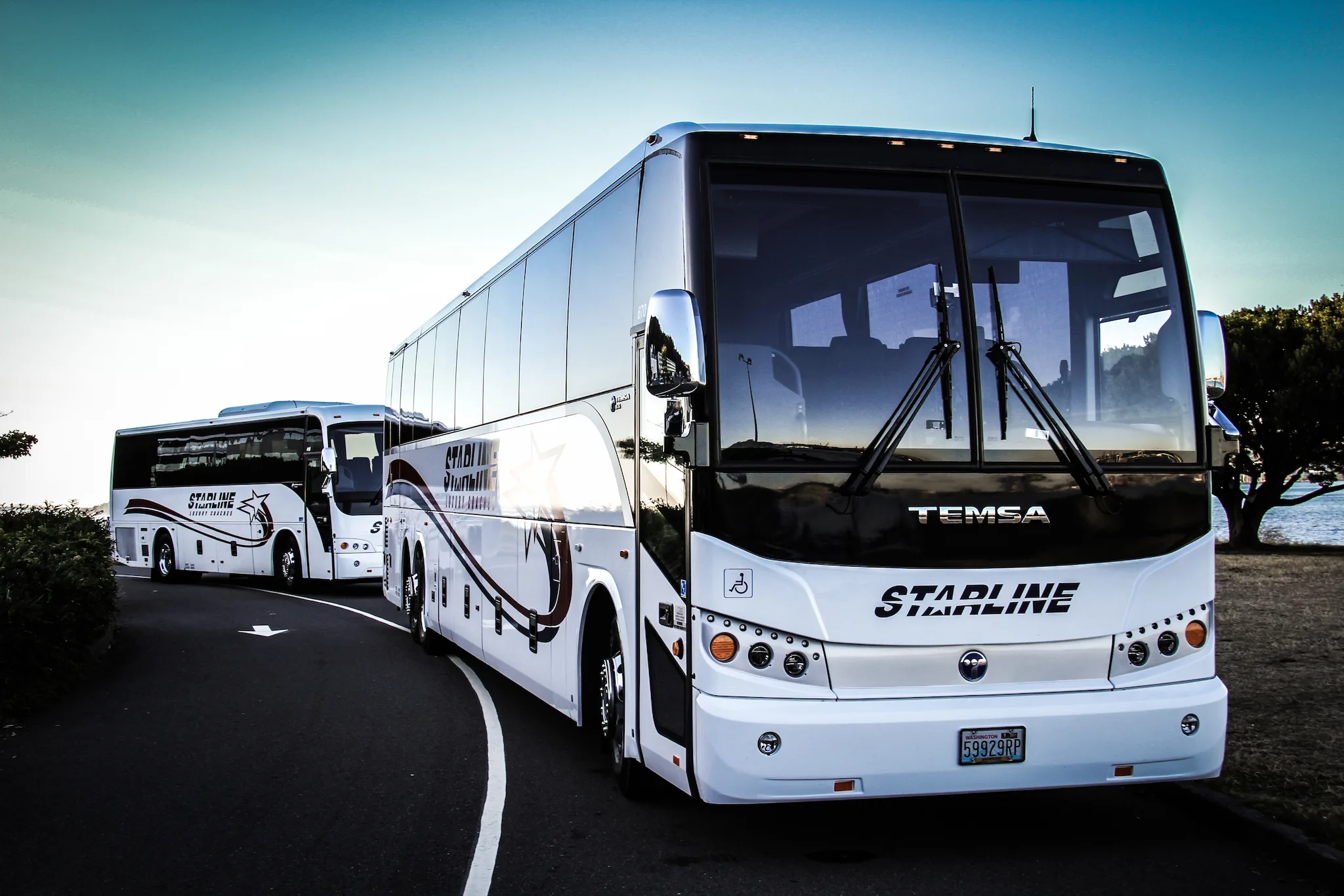 Two Starline Collection luxury TEMSA charter buses parked outdoors in the Pacific Northwest