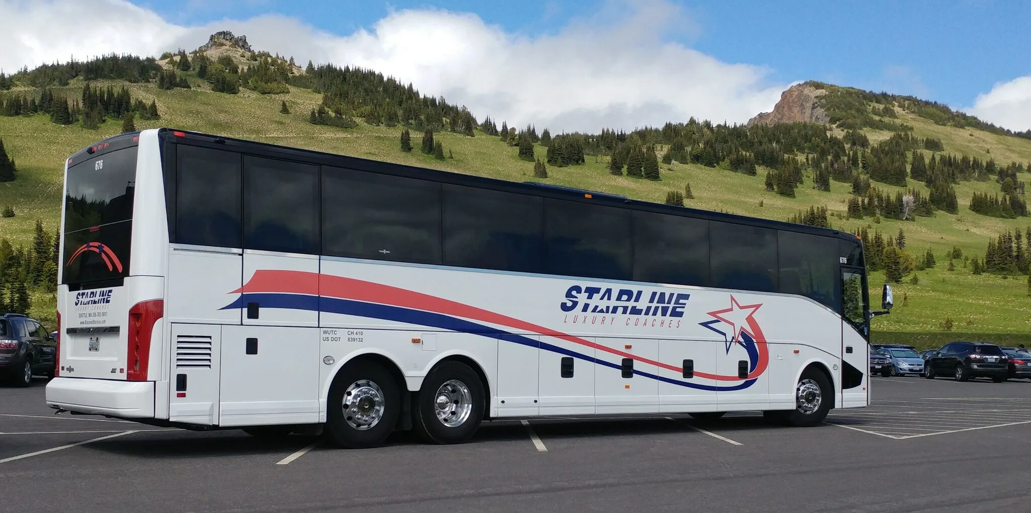 Starline Luxury Coaches charter bus parked against a scenic Pacific Northwest mountain landscape