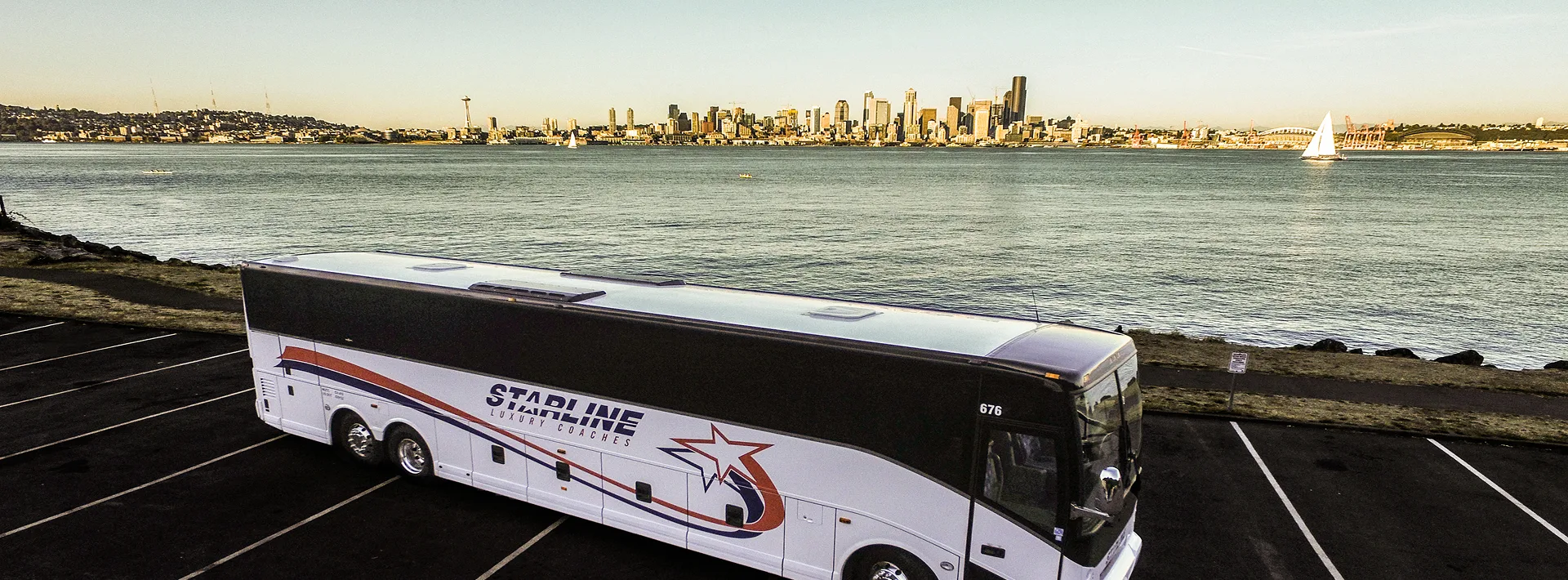 Starline Luxury Coaches charter bus parked waterfront with Seattle skyline and Space Needle in background