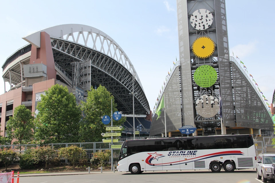 Starline Luxury Coaches motorcoach parked outside Lumen Field stadium in Seattle on a sunny day