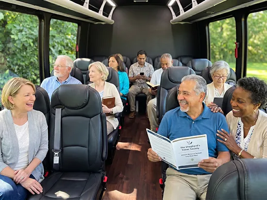 Diverse group of seniors enjoying a comfortable charter bus ride with leather seats and hardwood floors