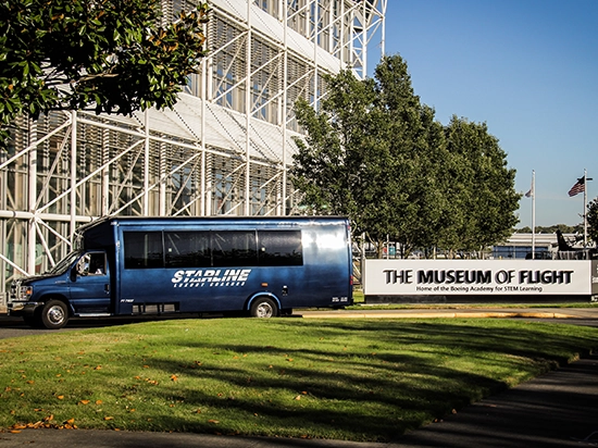 Starline luxury charter bus parked outside the Museum of Flight in Seattle on a sunny day