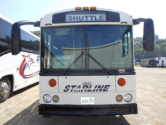 Front view of a Starline Collection white shuttle bus with illuminated destination sign
