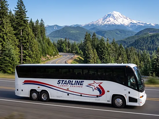 Starline Luxury Coaches charter bus traveling a scenic Pacific Northwest highway with Mount Rainier in background