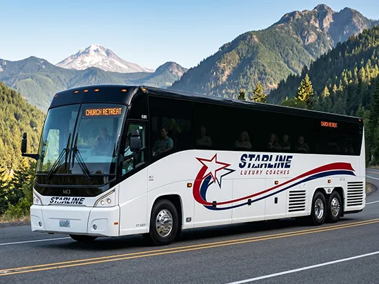 Starline Luxury Coaches charter bus on a scenic Pacific Northwest mountain highway