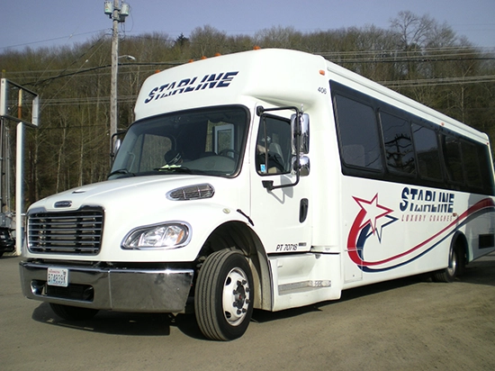 Starline Luxury Coaches white charter bus parked outdoors, featuring branded logo on side