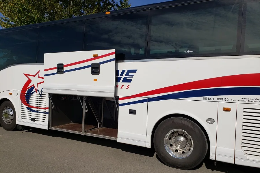 Starline Coaches charter bus with open undercarriage luggage bay, featuring red, white, and blue livery with star logo